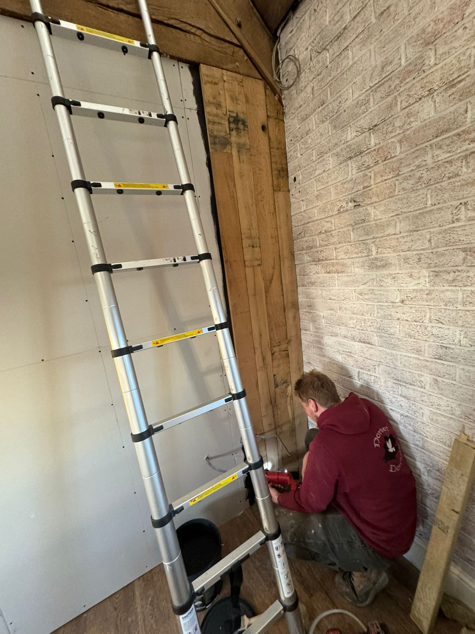 A person crouching at the bottom of a lader.